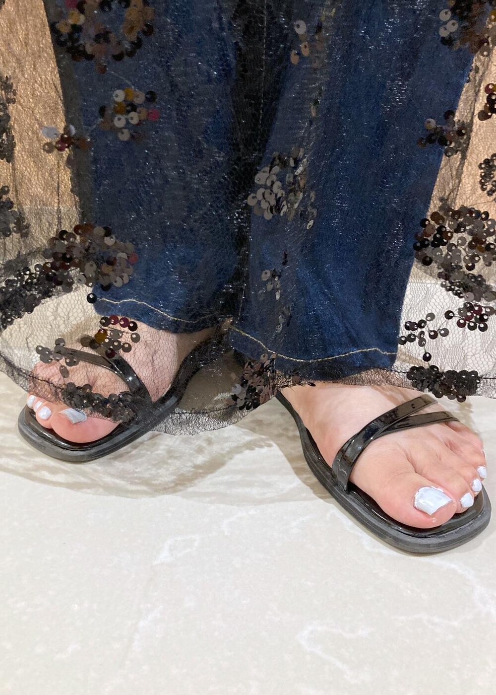 ブルー系のデニムパンツ、ブラック系のサンダル、ブラック系のスカートを着用したレディースの夏コーディネートの8枚目の写真