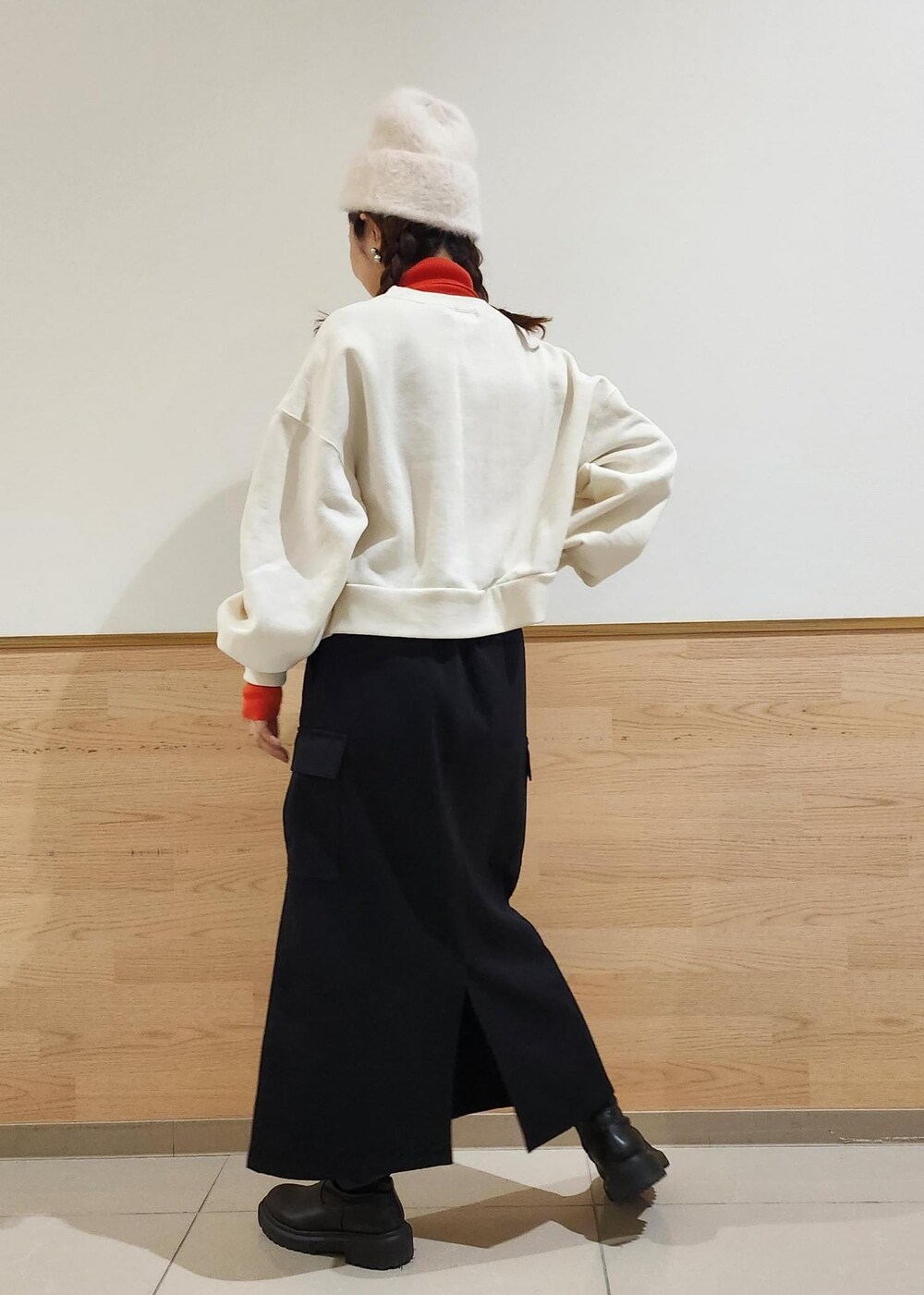 レッド系のニット/セーター、ホワイト系のダウンジャケット/コート、ブラック系のトートバッグを着用したレディースの冬コーディネートの3枚目の写真