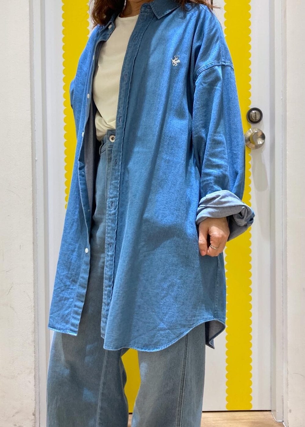 ホワイト系のTシャツ/カットソー、ブルー系のデニムパンツ、シルバー系のショルダーバッグを着用したレディースの春コーディネートの4枚目の写真