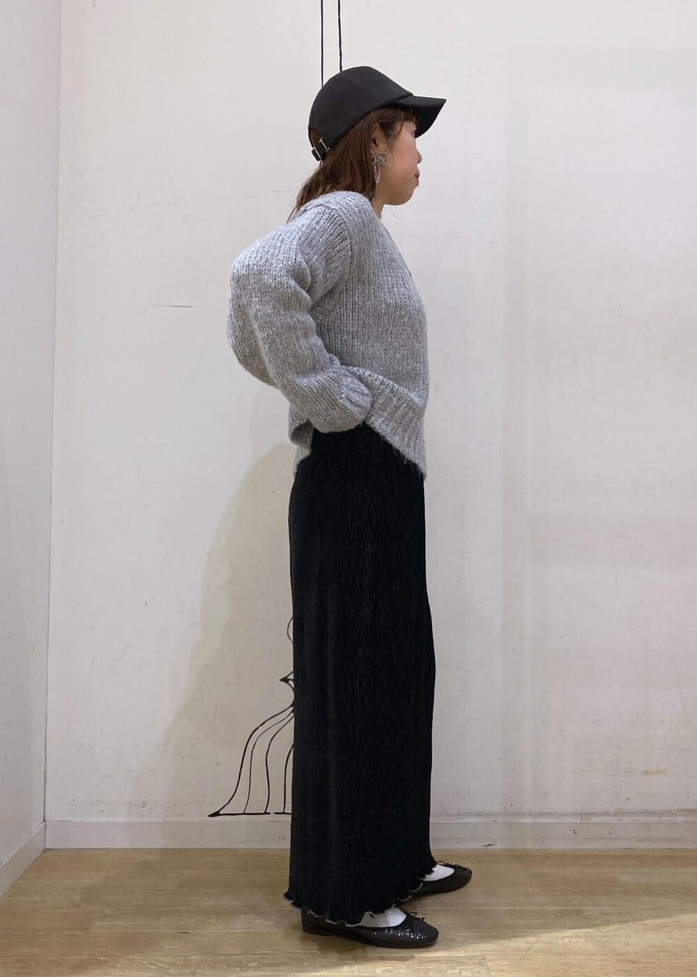 ホワイト系のTシャツ/カットソー、グレー系のニット/セーター、レッド系のトートバッグを着用したレディースの冬コーディネートの3枚目の写真