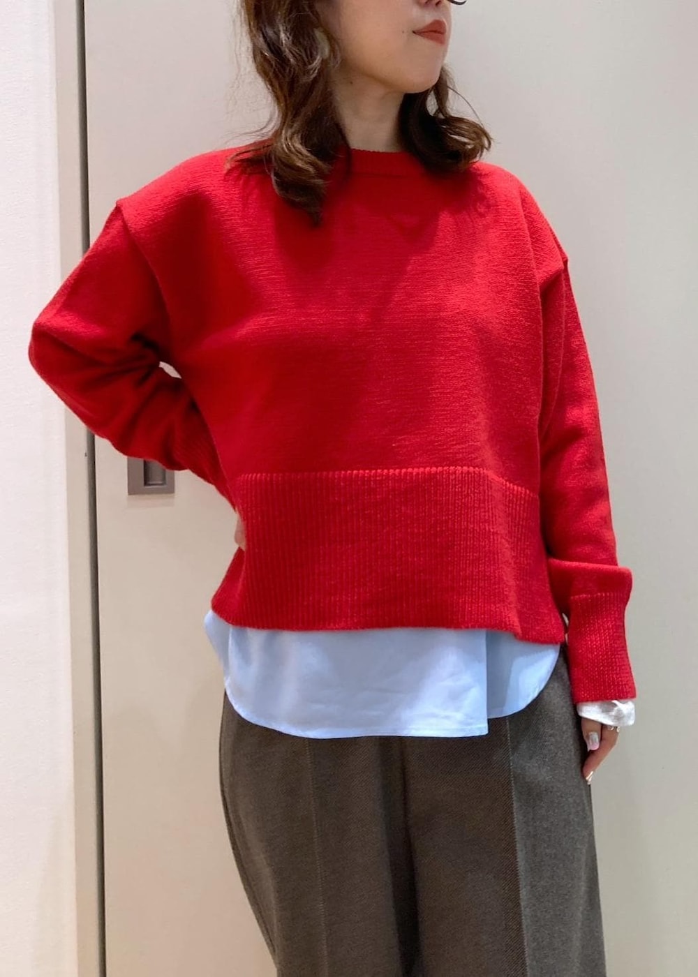 レッド系のニット/セーター、レッド系のブーツ、グレー系のトートバッグを着用したレディースの秋コーディネートの4枚目の写真