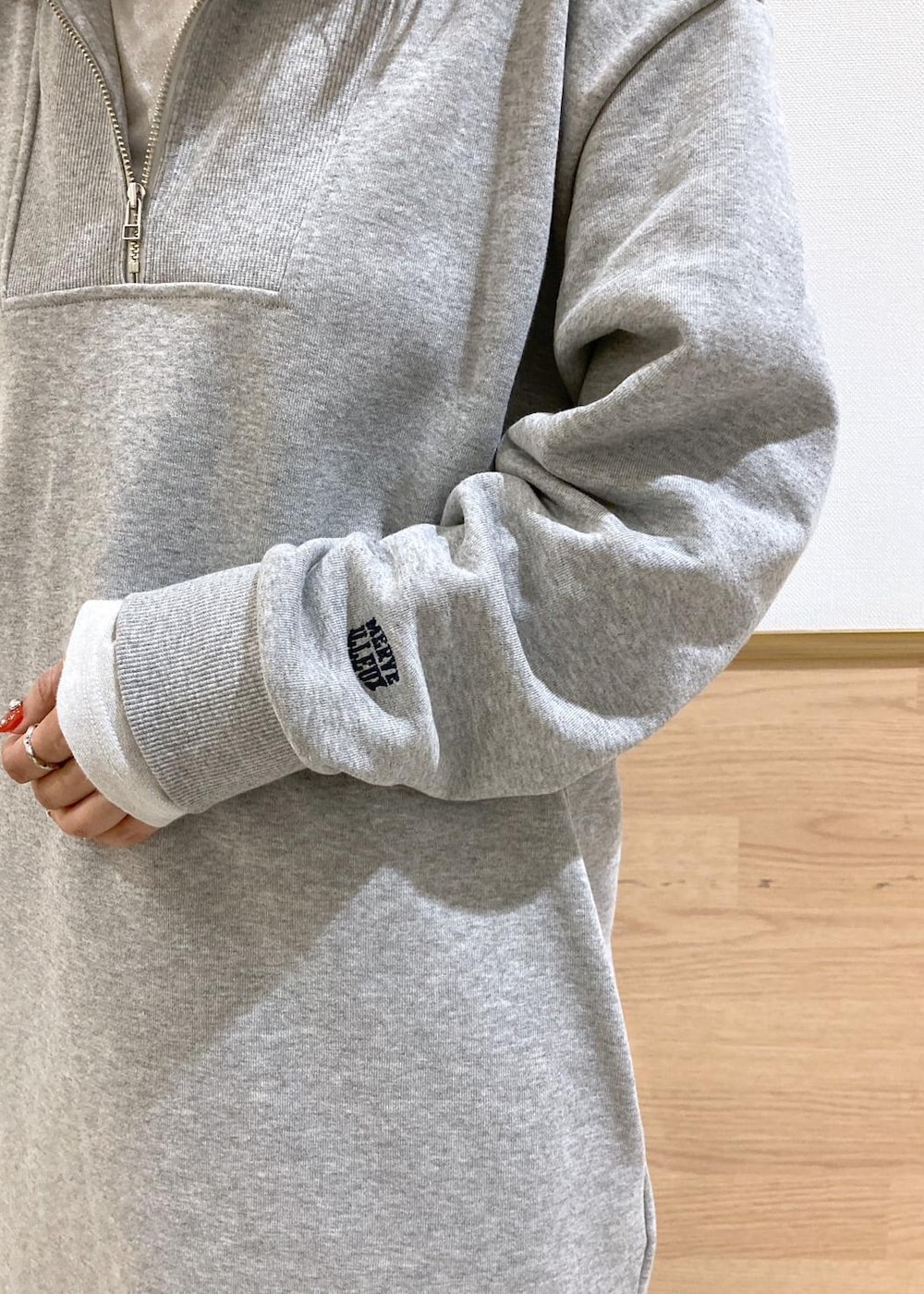 ホワイト系のTシャツ/カットソー、ブルー系のデニムパンツ、グレー系のワンピースを着用したレディースの秋コーディネートの7枚目の写真