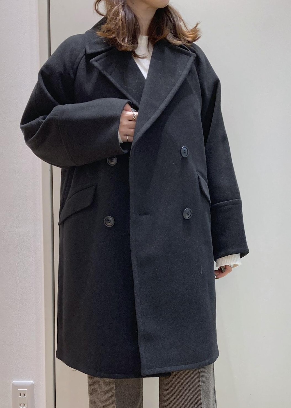 ホワイト系のニット/セーター、ブラウン系のその他パンツ、ブラック系のピーコートを着用したレディースの冬コーディネートの4枚目の写真