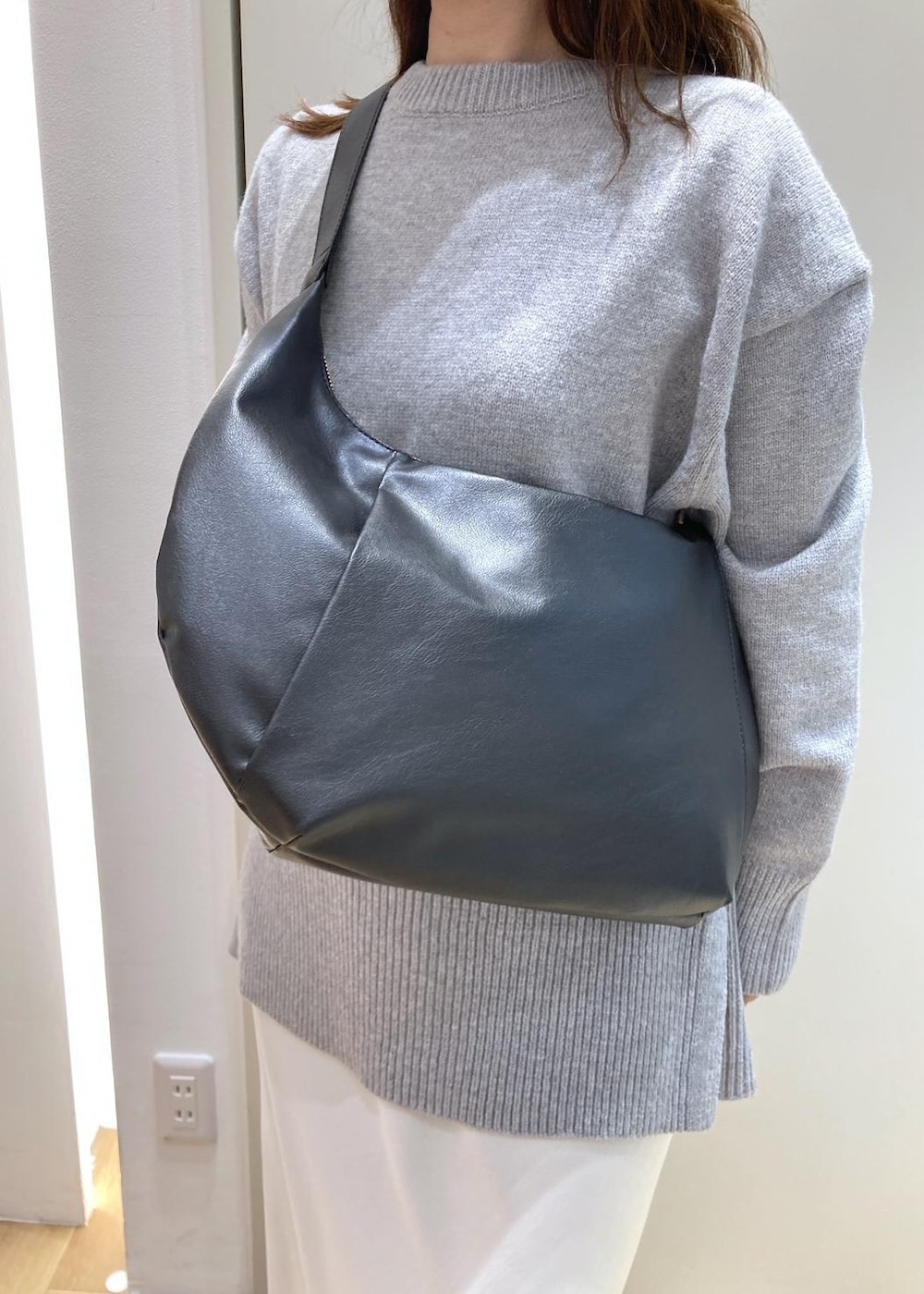 グレー系のニット/セーター、ホワイト系のスニーカー、ブラック系のショルダーバッグを着用したレディースの冬コーディネートの9枚目の写真