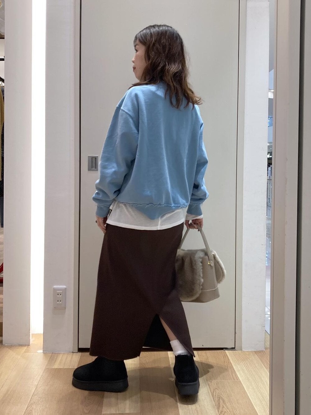 ホワイト系のTシャツ/カットソー、ブラック系のブーツ、ブラウン系のショルダーバッグを着用したレディースの冬コーディネートの3枚目の写真