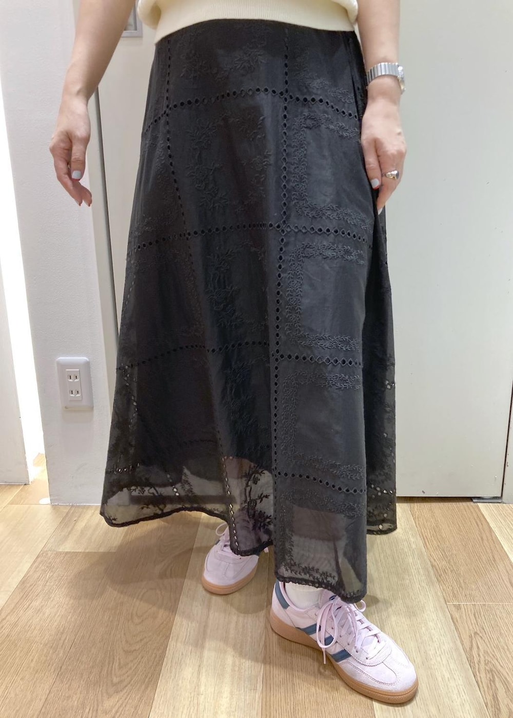 ブラック系のバックパック/リュック、ブラック系のスカート、ホワイト系のニット/セーターを着用したレディースの春コーディネートの5枚目の写真