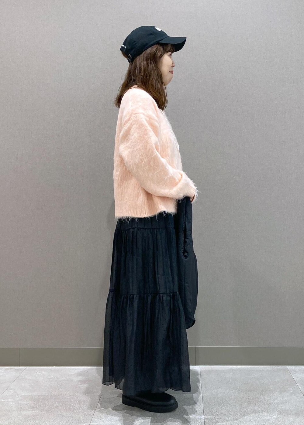 ブラック系のブーツ、ブラック系のトートバッグ、ピンク系のニット/セーターを着用したレディースの冬コーディネートの3枚目の写真