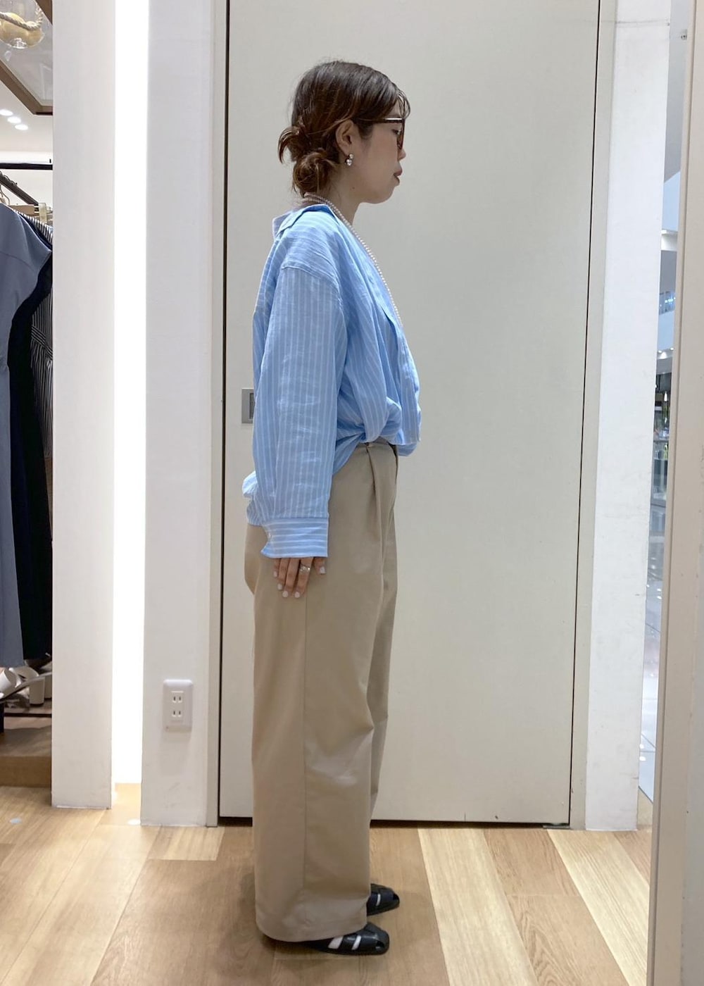 ベージュ系のチノパンツ、ブラック系のサンダル、ホワイト系のショルダーバッグを着用したレディースの春コーディネートの2枚目の写真