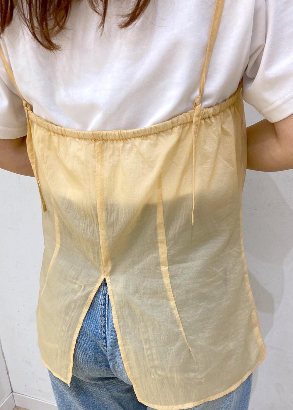 ホワイト系のTシャツ/カットソー、ベージュ系のサンダル、オレンジ系のベストを着用したレディースの夏コーディネートの6枚目の写真