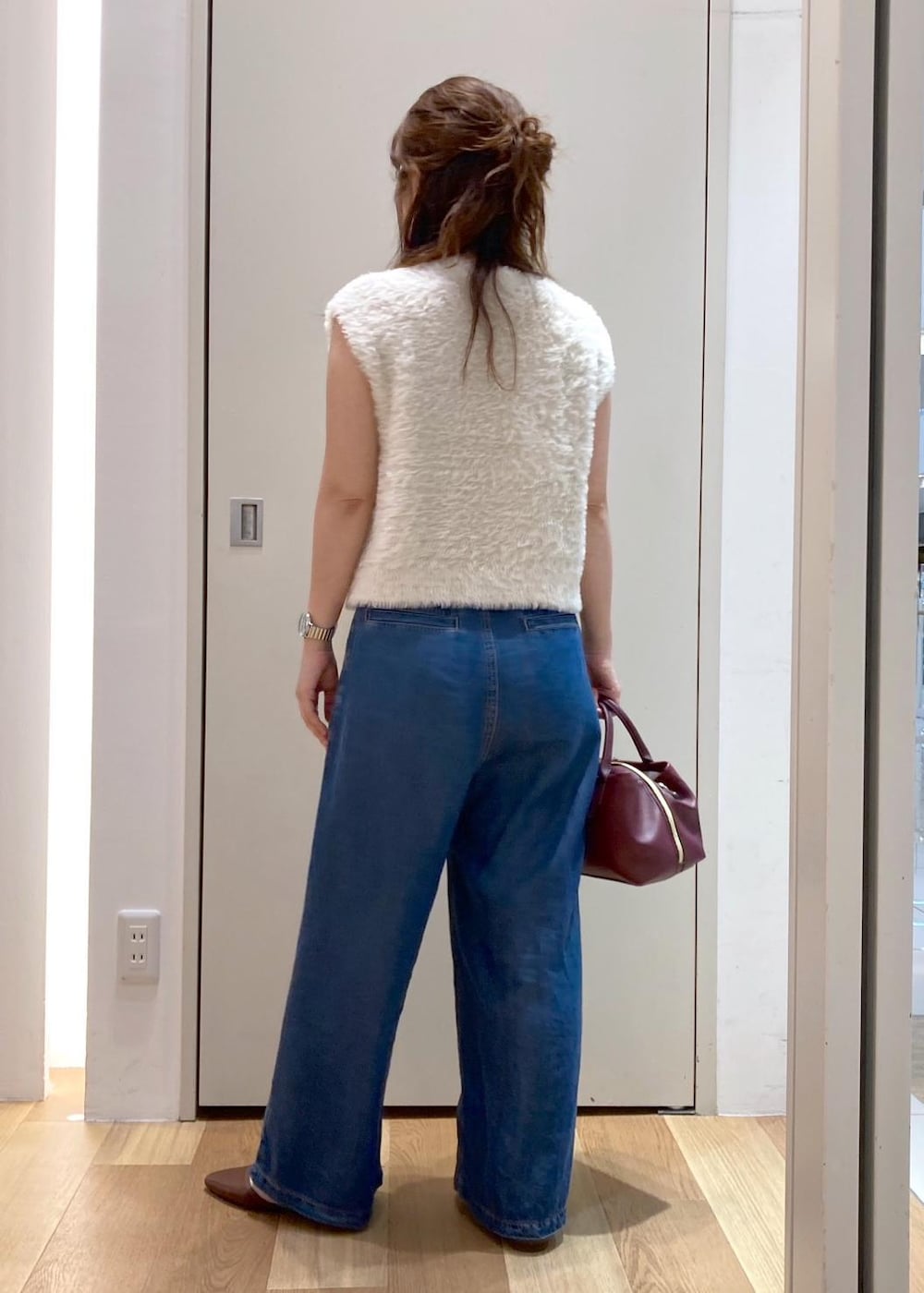 ブラウン系のパンプス、ブルー系のデニムパンツ、レッド系のトートバッグを着用したレディースの夏コーディネートの3枚目の写真