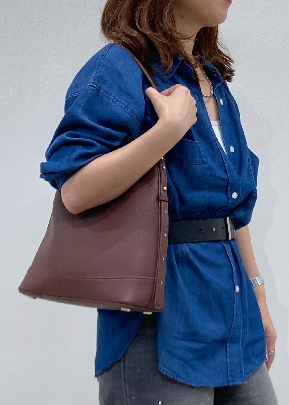 レッド系のショルダーバッグ、ブルー系のシャツ/ブラウス、ブラック系のデニムパンツを着用したレディースの夏コーディネートの7枚目の写真