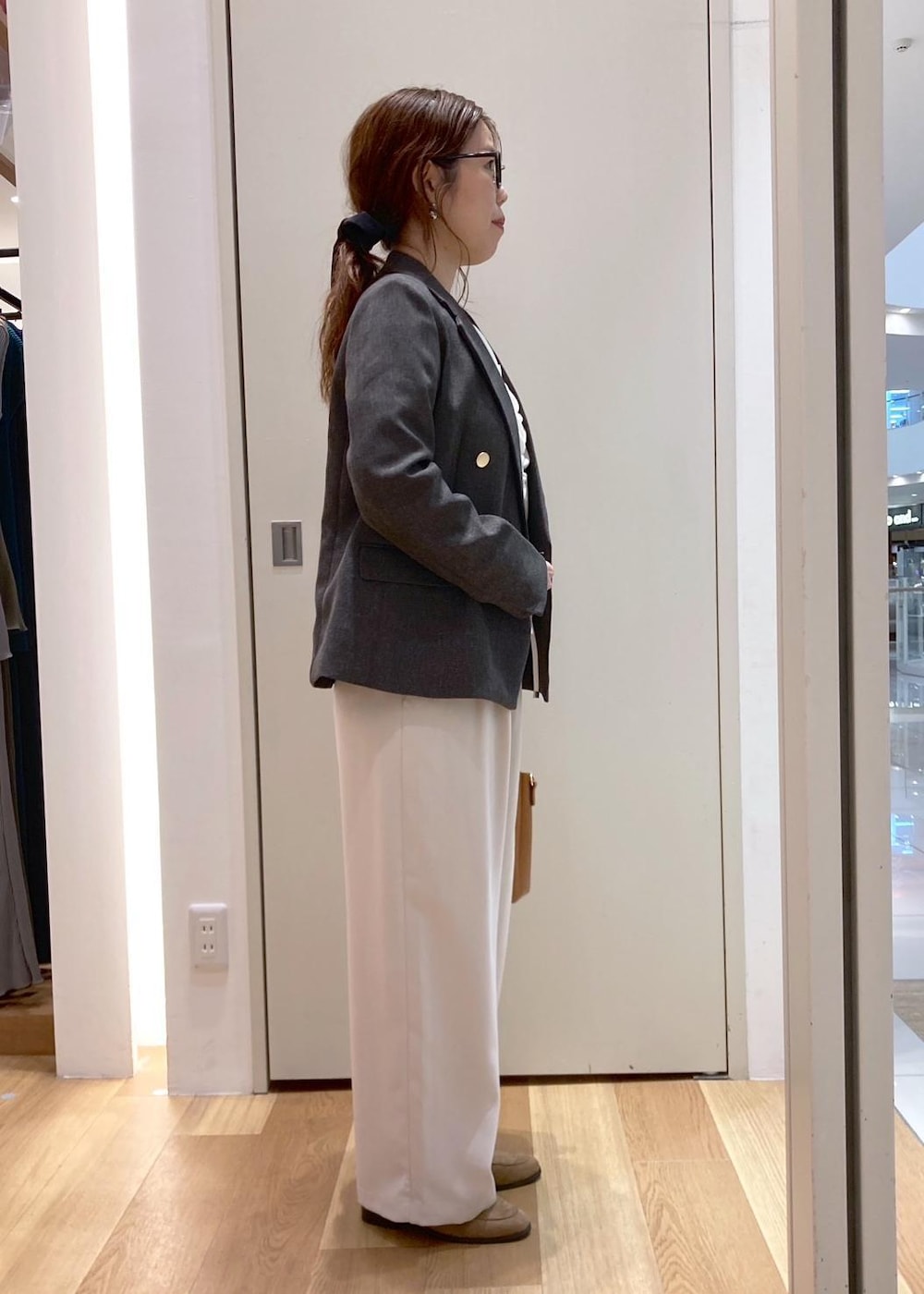 ブラウン系のトートバッグ、ホワイト系のその他パンツ、ブラウン系のテーラードジャケットを着用したレディースの秋コーディネートの2枚目の写真