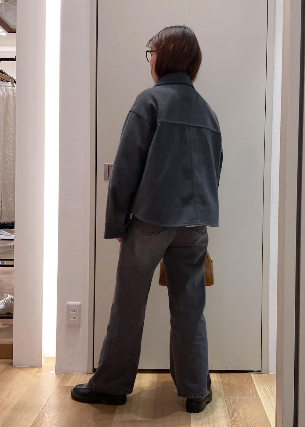 グレー系のブルゾン、グレー系のニット/セーター、ホワイト系のTシャツ/カットソーを着用したレディースの秋コーディネートの3枚目の写真