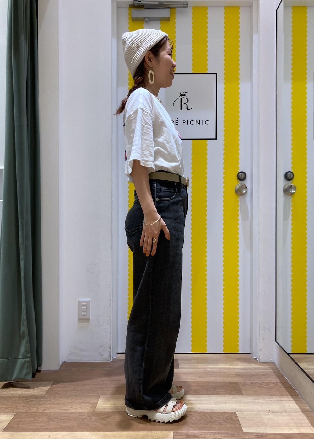 ホワイト系のサンダル、ゴールド系のショルダーバッグ、ブラック系のデニムパンツを着用したレディースの夏コーディネートの5枚目の写真