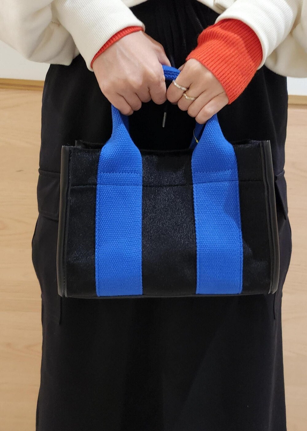 レッド系のニット/セーター、ホワイト系のダウンジャケット/コート、ブラック系のトートバッグを着用したレディースの冬コーディネートの8枚目の写真