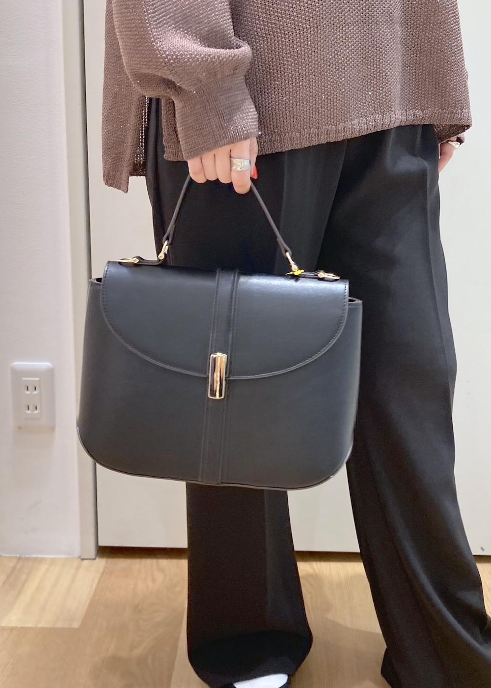 ブラック系のショルダーバッグ、イエロー系のニット/セーター、ブラウン系のテーラードジャケットを着用したレディースの春コーディネートの8枚目の写真