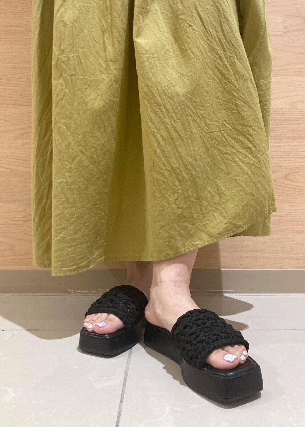 ブラック系のサンダル、ブラック系のかごバッグ、イエロー系のワンピースを着用したレディースの夏コーディネートの10枚目の写真