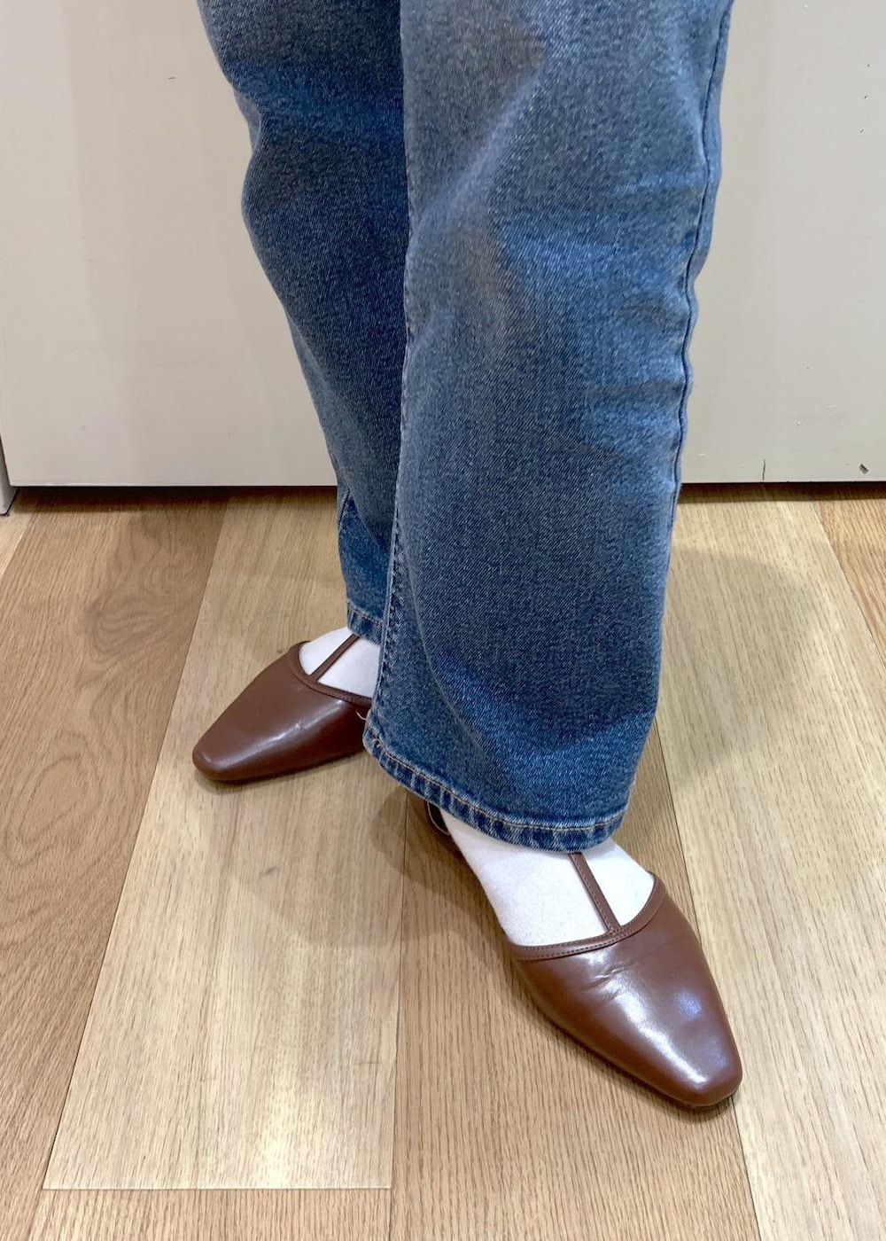 ブラウン系のボストンバッグ、ブルー系のデニムパンツ、ブラウン系のパンプスを着用したレディースの春コーディネートの9枚目の写真