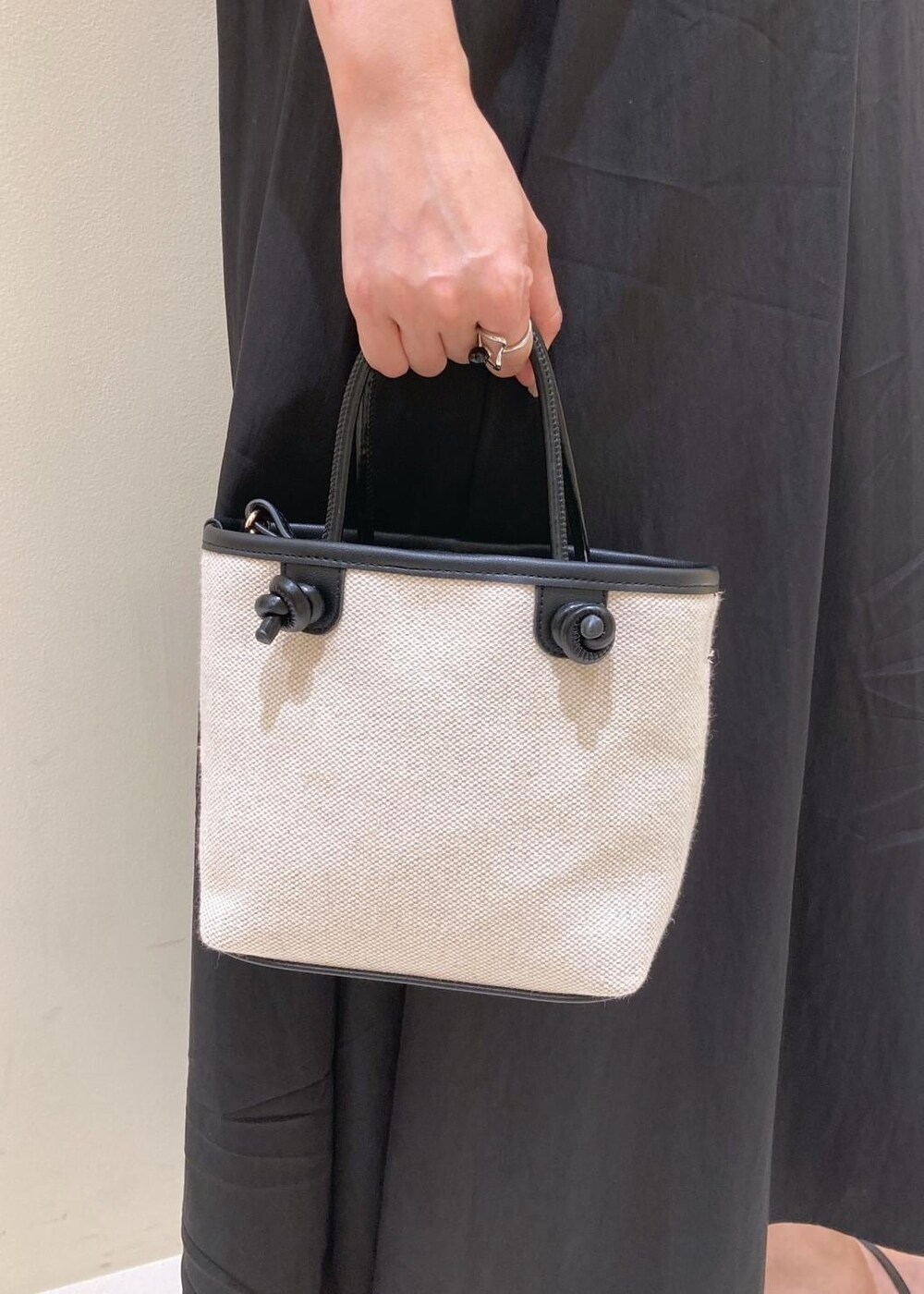 ブラック系のサンダル、ブラック系のワンピース、グレー系のカーディガン/ボレロを着用したレディースの夏コーディネートの8枚目の写真