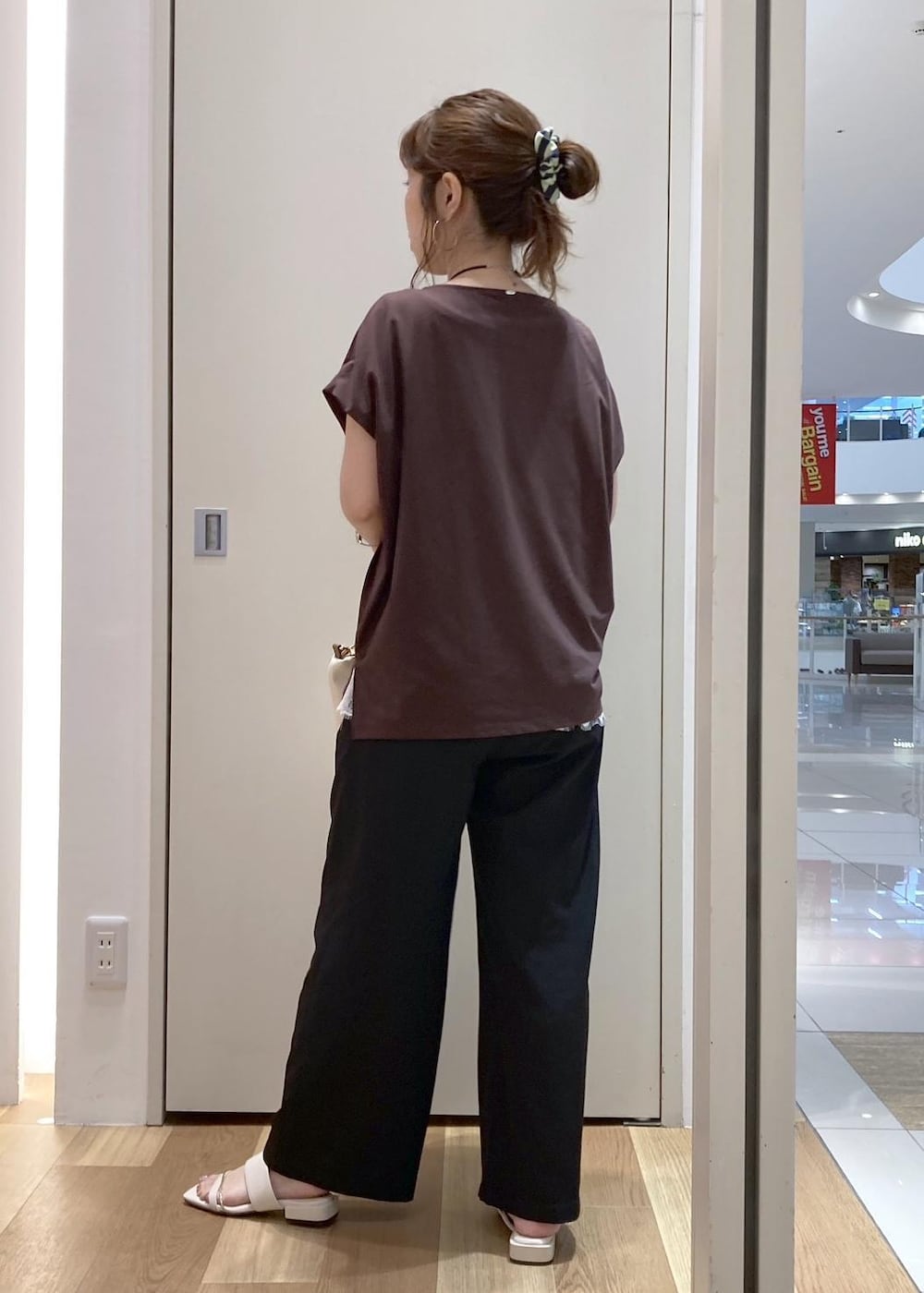ブラック系のその他パンツ、ホワイト系のショルダーバッグ、ブラウン系のTシャツ/カットソーを着用したレディースの夏コーディネートの3枚目の写真