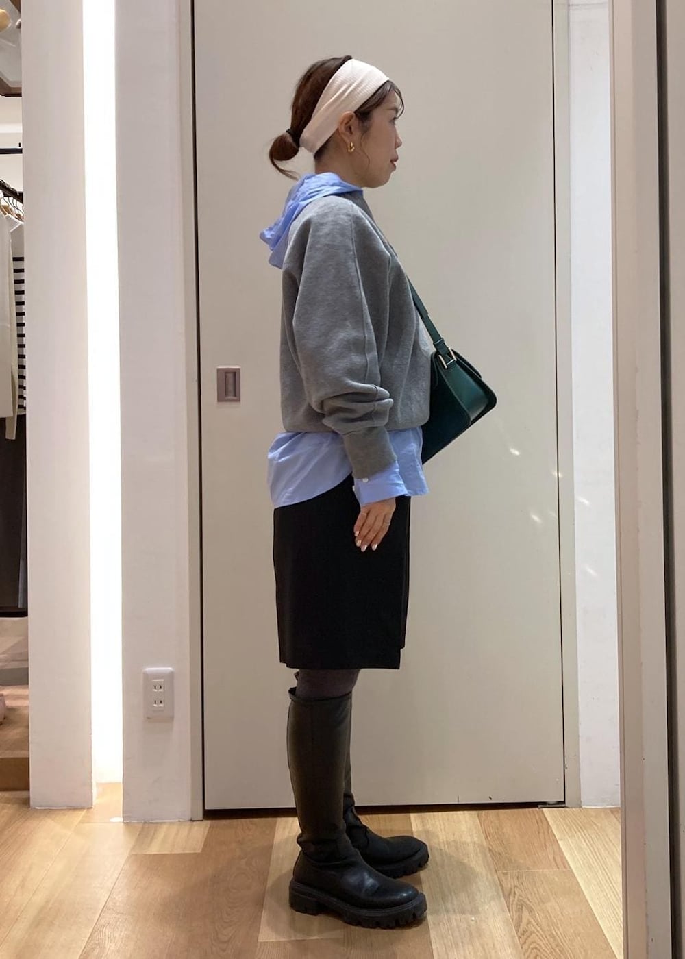 グリーン系のショルダーバッグ、ブルー系のシャツ/ブラウス、グレー系のニット/セーターを着用したレディースの秋コーディネートの2枚目の写真