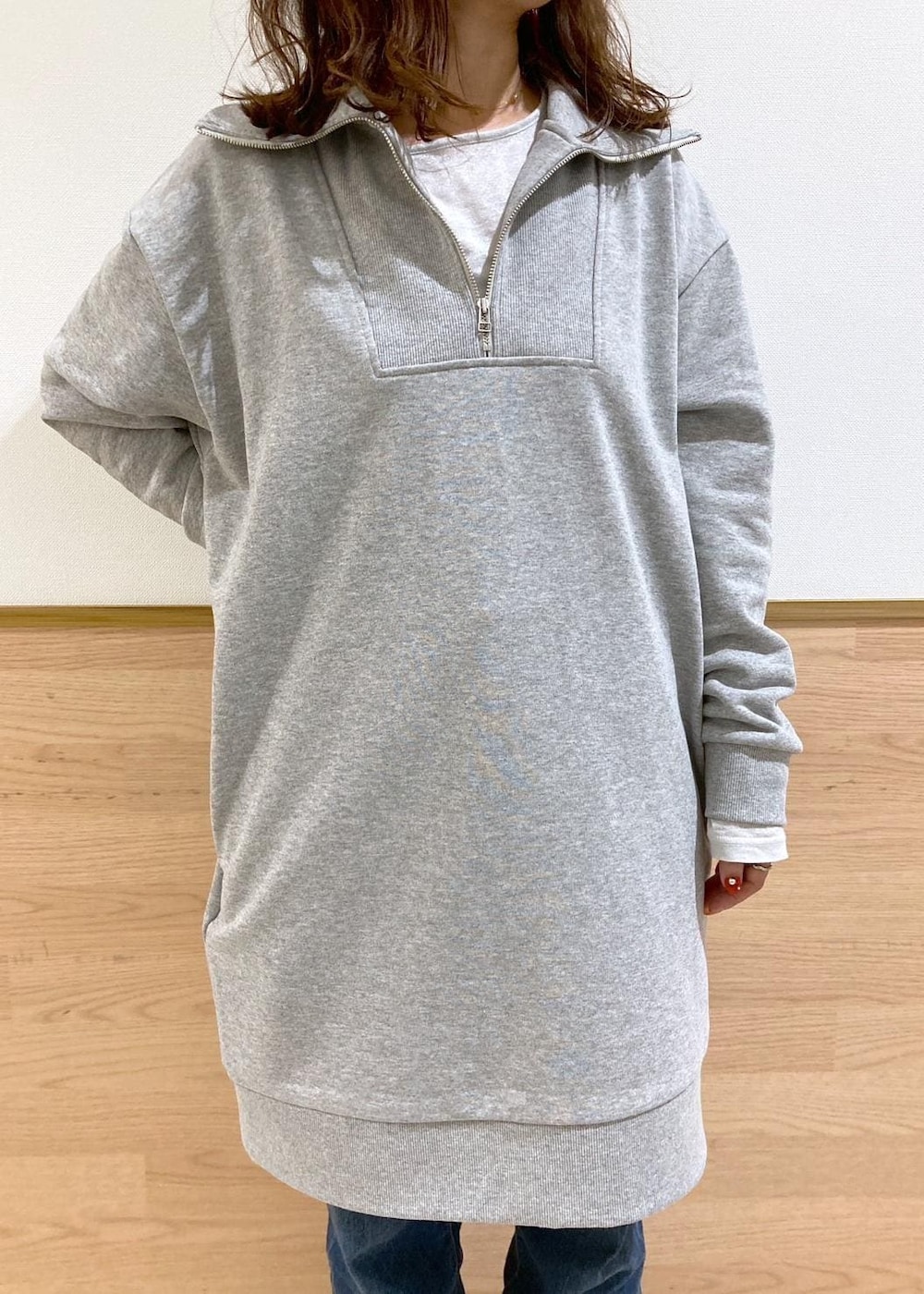 ホワイト系のTシャツ/カットソー、ブルー系のデニムパンツ、グレー系のワンピースを着用したレディースの秋コーディネートの6枚目の写真