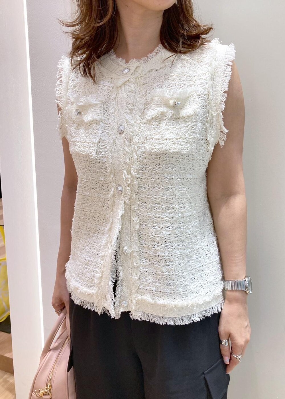 ピンク系のボストンバッグ、ブラック系のパンプス、ブラック系のカーゴパンツを着用したレディースの夏コーディネートの5枚目の写真