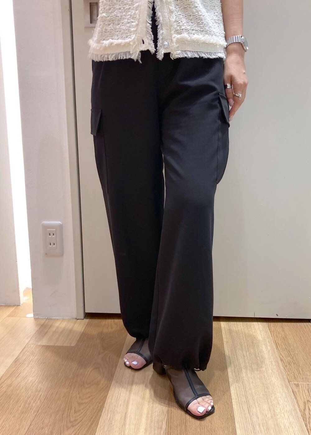 ピンク系のボストンバッグ、ブラック系のパンプス、ブラック系のカーゴパンツを着用したレディースの夏コーディネートの6枚目の写真