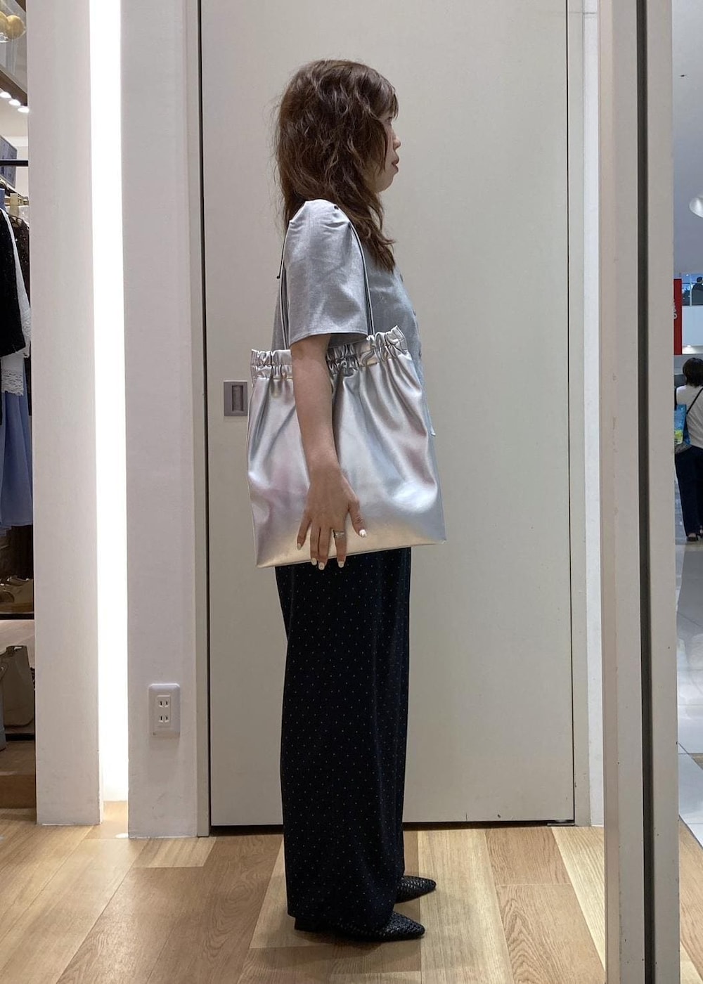ブラック系のパンプス、シルバー系のトートバッグ、グレー系のシャツ/ブラウスを着用したレディースの夏コーディネートの2枚目の写真