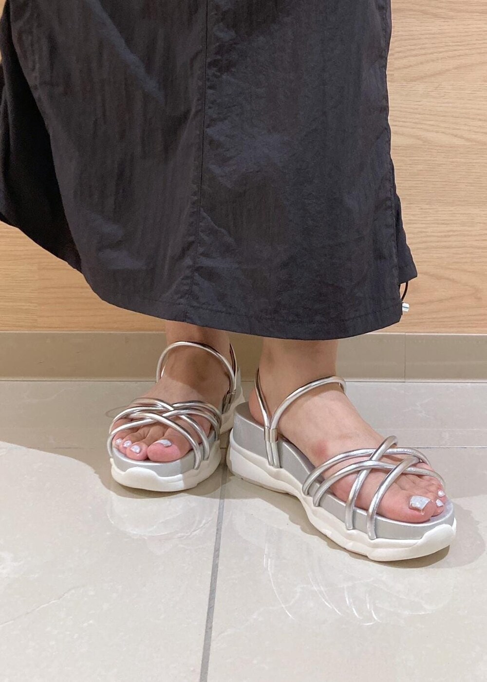 シルバー系のサンダル、ブラック系のワンピース、シルバー系のトートバッグを着用したレディースの夏コーディネートの10枚目の写真