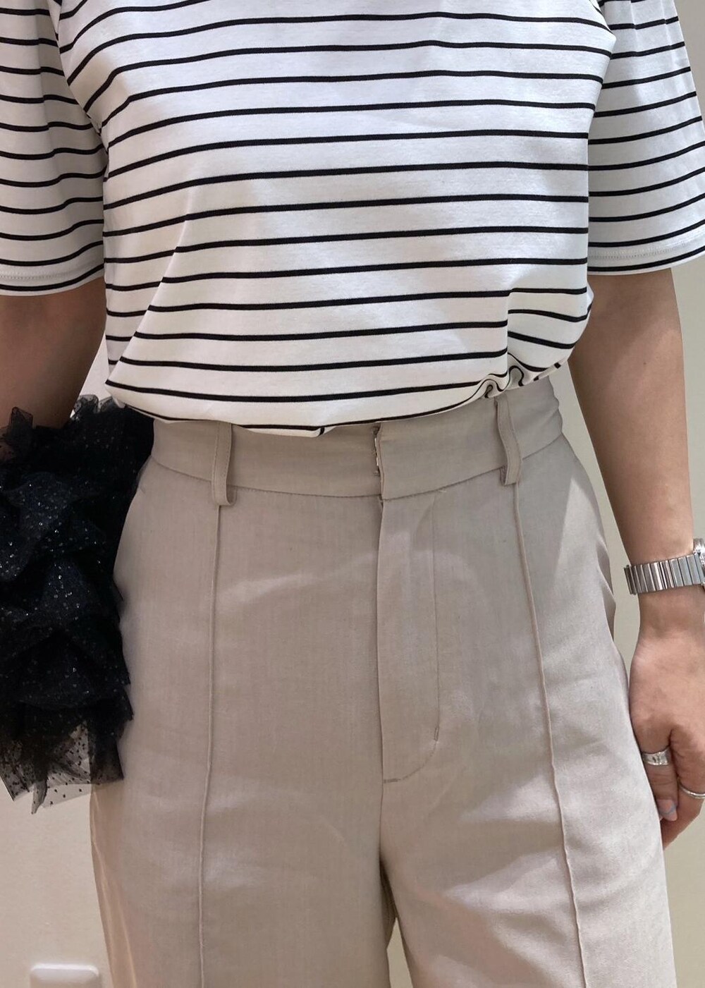 ブラック系のショルダーバッグ、シルバー系のパンプス、ベージュ系のその他パンツを着用したレディースの夏コーディネートの5枚目の写真