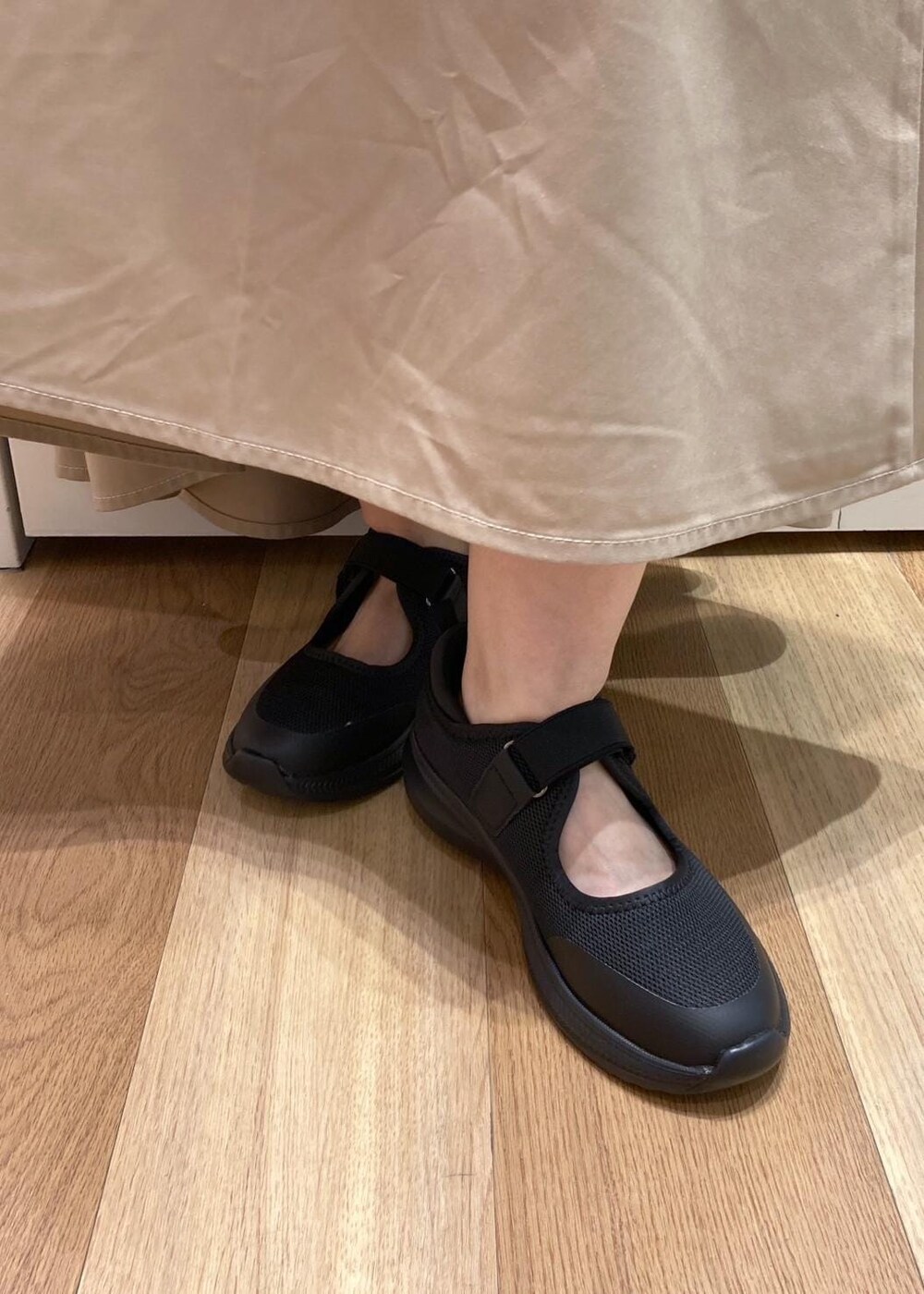 ブラック系のスニーカー、ベージュ系のスカート、ブラック系のシャツ/ブラウスを着用したレディースの夏コーディネートの7枚目の写真