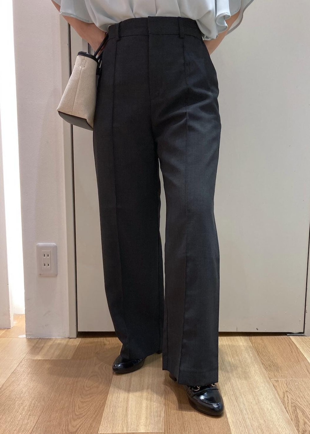 ブラック系のローファー、グレー系のその他パンツ、ブラック系のトートバッグを着用したレディースの夏コーディネートの5枚目の写真