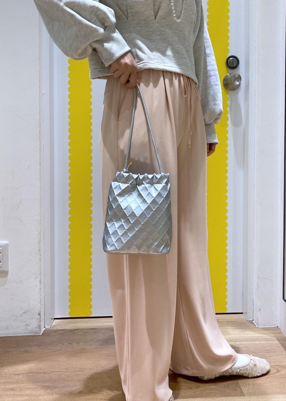 グレー系のスウェット、シルバー系のショルダーバッグ、ピンク系のその他パンツを着用したレディースの冬コーディネートの5枚目の写真