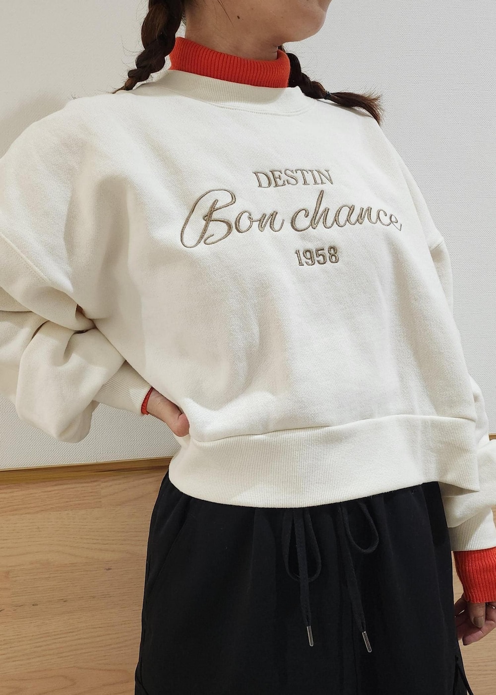 レッド系のニット/セーター、ホワイト系のダウンジャケット/コート、ブラック系のトートバッグを着用したレディースの冬コーディネートの4枚目の写真