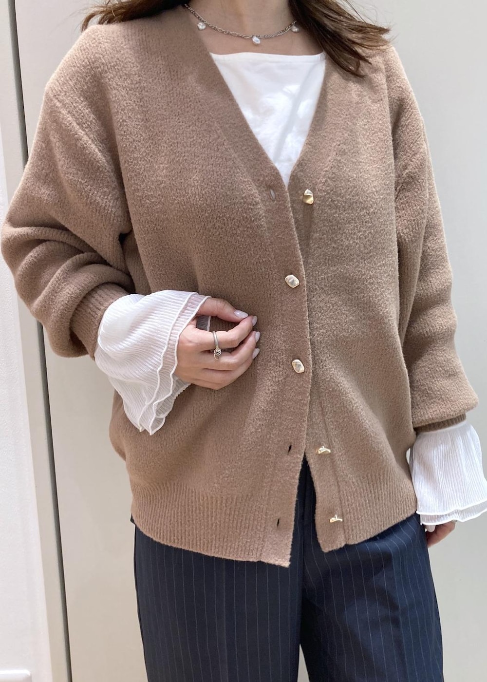 ベージュ系のカーディガン/ボレロ、ホワイト系のTシャツ/カットソー、ブルー系のその他パンツを着用したレディースの冬コーディネートの4枚目の写真