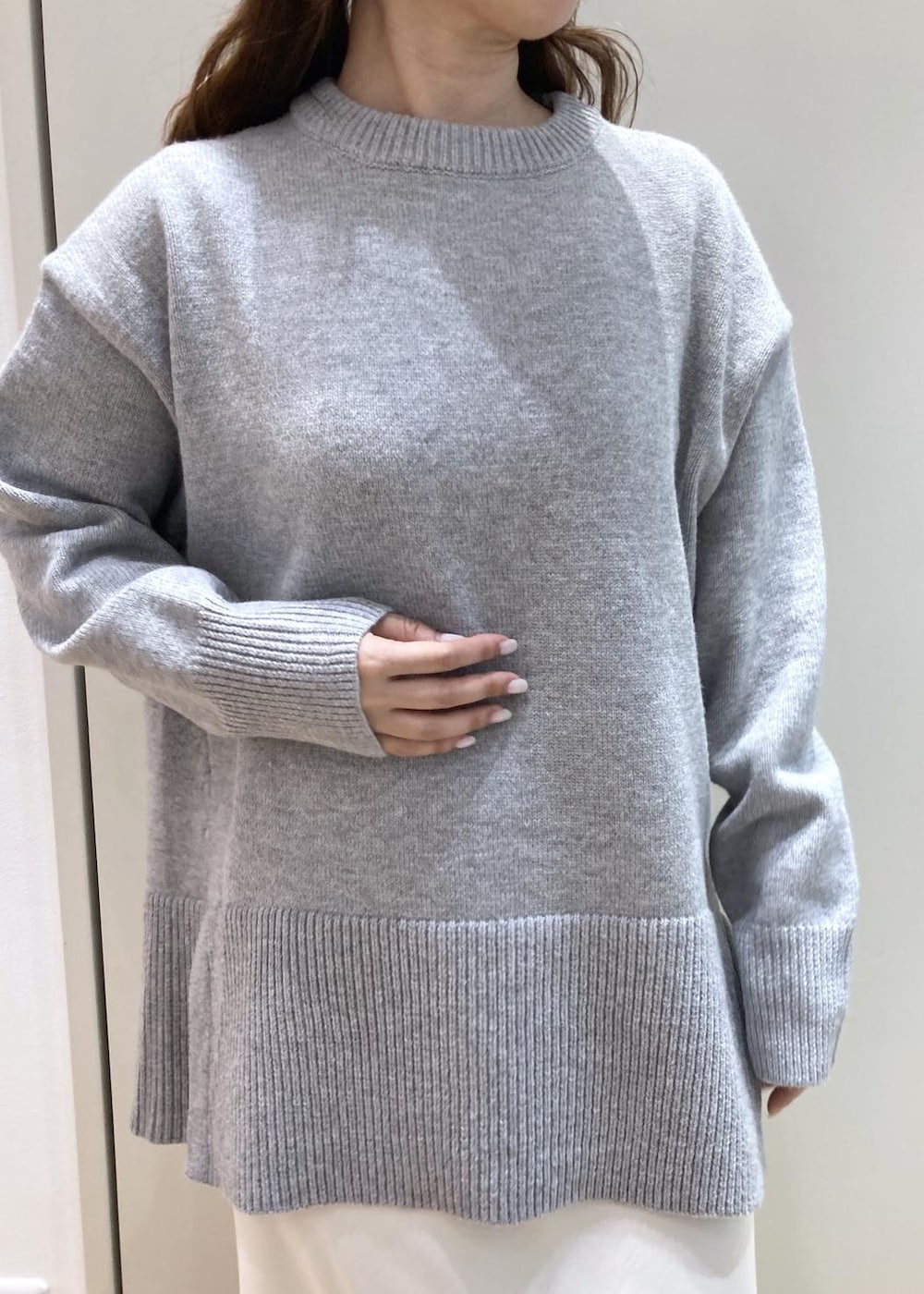 グレー系のニット/セーター、ホワイト系のスニーカー、ブラック系のショルダーバッグを着用したレディースの冬コーディネートの4枚目の写真