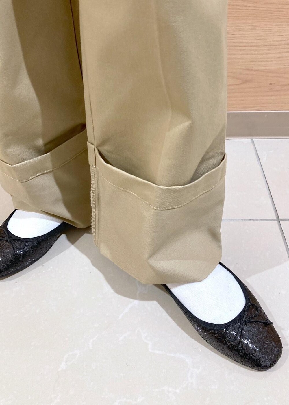 ホワイト系のニット/セーター、ブラック系のバレエシューズ、ベージュ系のチノパンツを着用したレディースの冬コーディネートの7枚目の写真