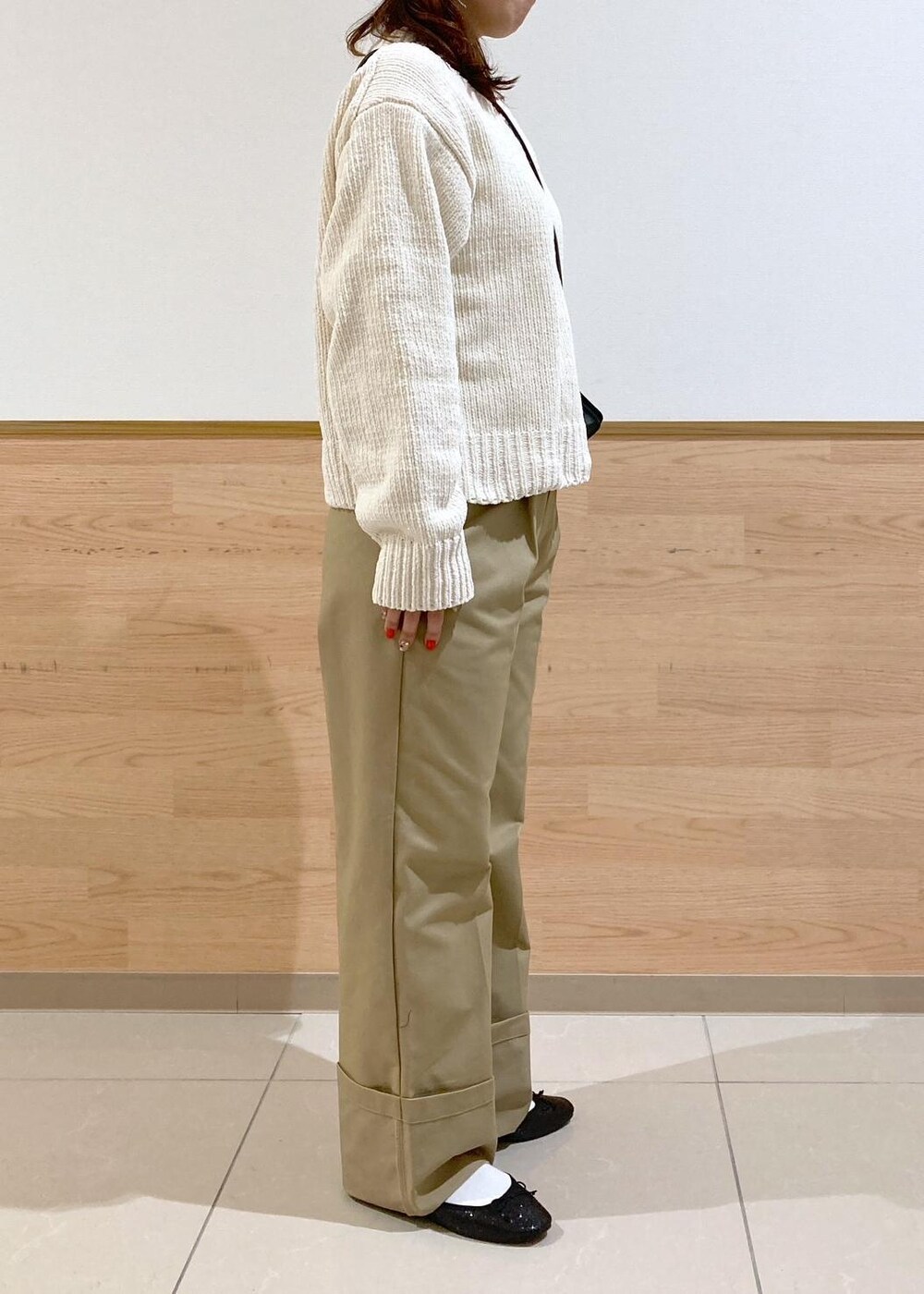 ホワイト系のニット/セーター、ブラック系のバレエシューズ、ベージュ系のチノパンツを着用したレディースの冬コーディネートの2枚目の写真