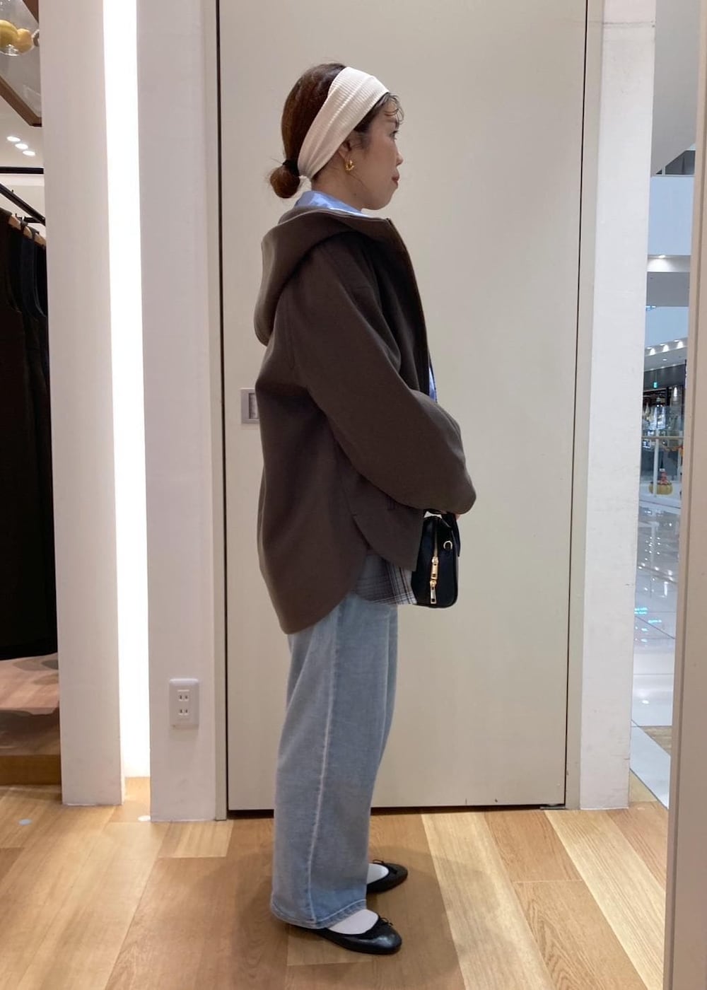 ブルー系のデニムパンツ、ブラック系のバレエシューズ、グレー系のシャツ/ブラウスを着用したレディースの秋コーディネートの2枚目の写真