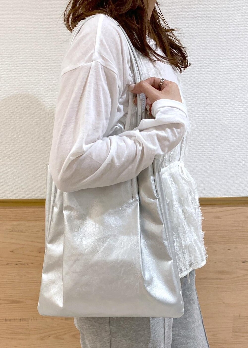 ホワイト系のベスト、シルバー系のトートバッグ、グレー系のその他パンツを着用したレディースの春コーディネートの9枚目の写真