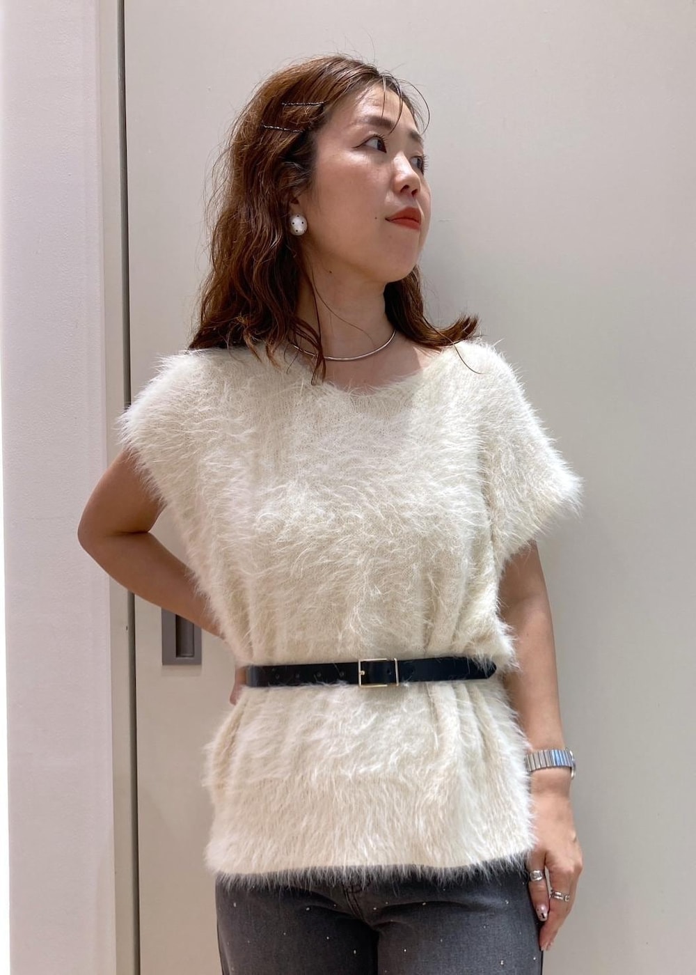 ホワイト系のベスト、ブラック系のデニムパンツ、ブラック系のショルダーバッグを着用したレディースの夏コーディネートの5枚目の写真