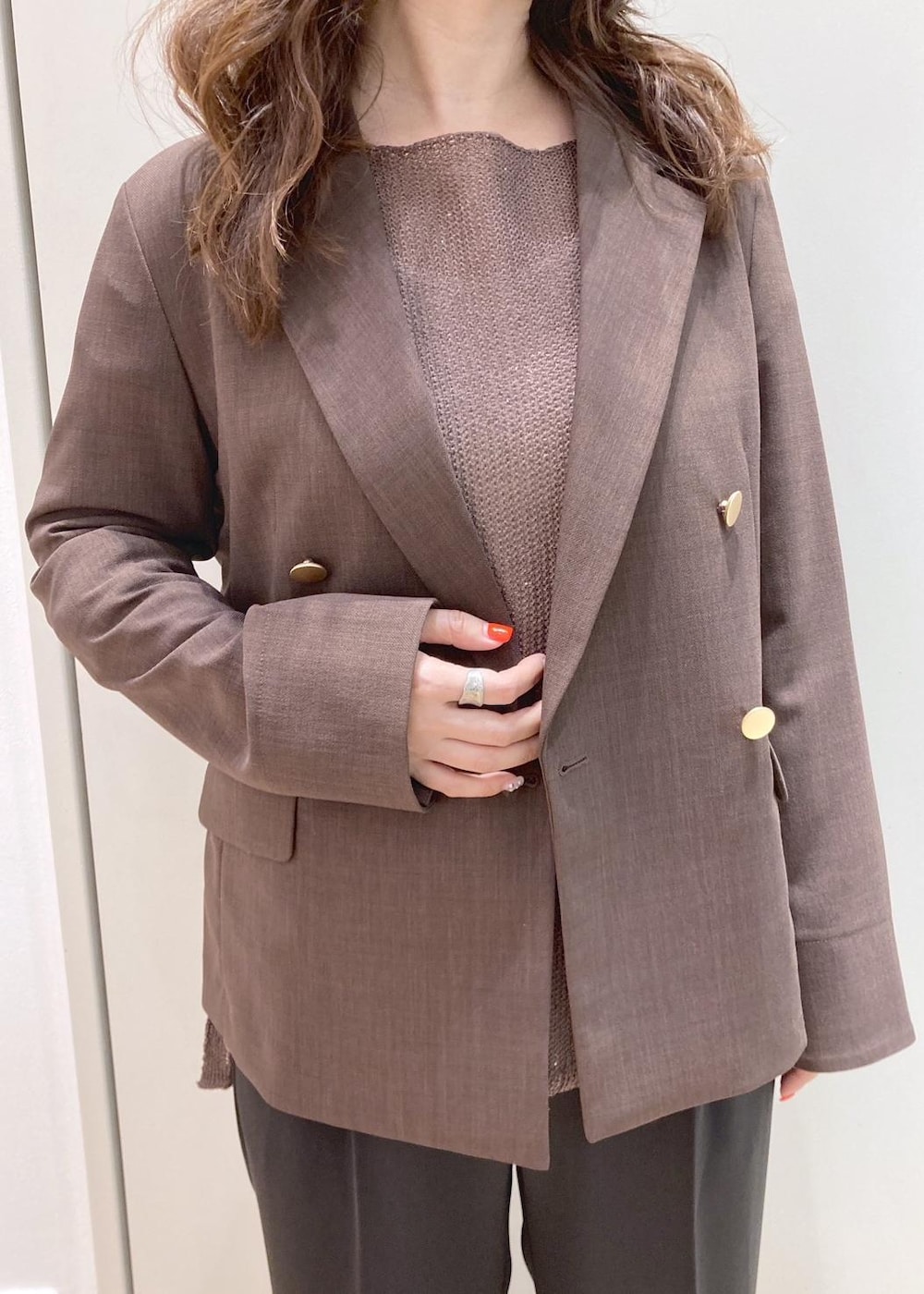 ブラック系のショルダーバッグ、イエロー系のニット/セーター、ブラウン系のテーラードジャケットを着用したレディースの春コーディネートの4枚目の写真