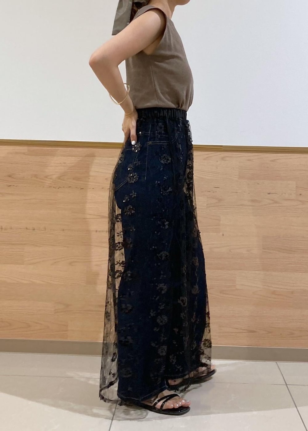 ブルー系のデニムパンツ、ブラック系のサンダル、ブラック系のスカートを着用したレディースの夏コーディネートの2枚目の写真