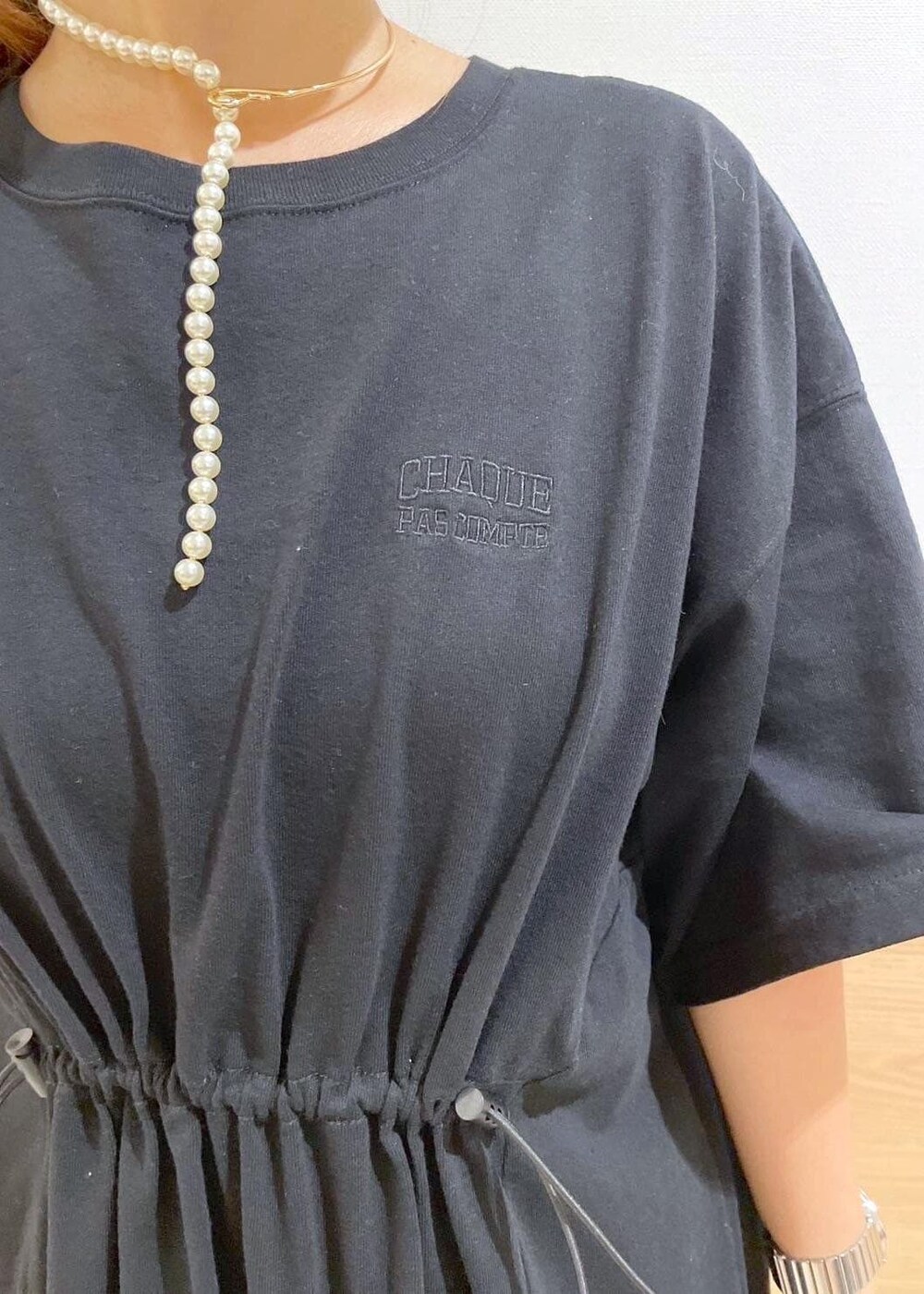 ブラウン系のテーラードジャケット、ブラック系のハンドバッグ、ブラック系のワンピースを着用したレディースの秋コーディネートの7枚目の写真