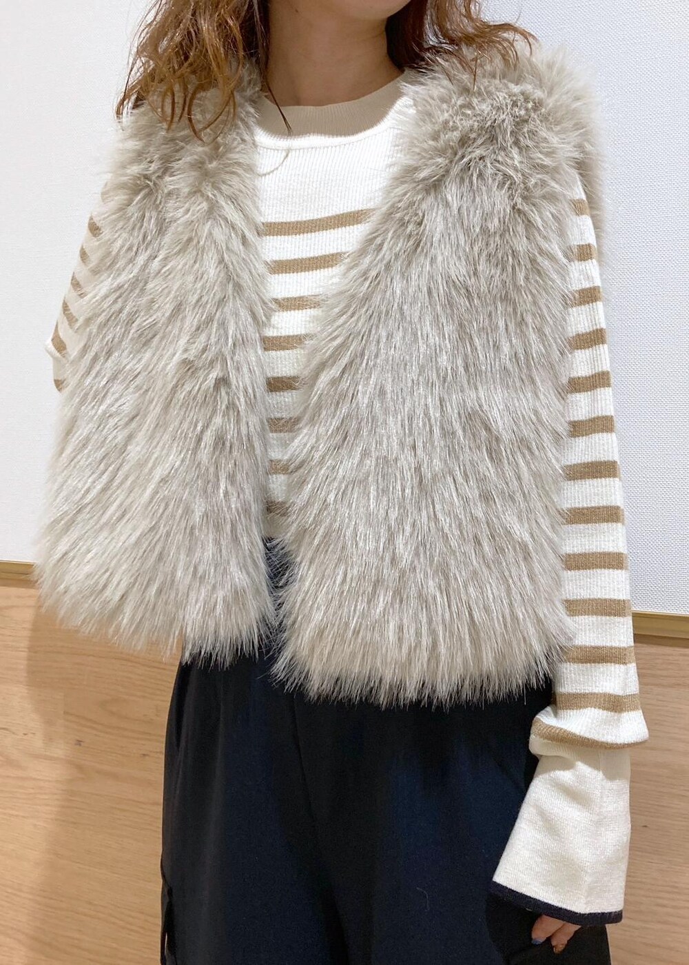 イエロー系のショルダーバッグ、ベージュ系のニット/セーター、ベージュ系のベストを着用したレディースの秋コーディネートの5枚目の写真