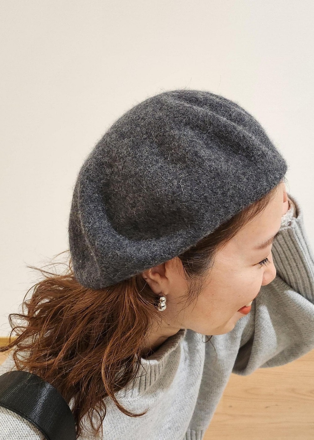 グレー系のニット/セーター、ブラック系のショルダーバッグ、ホワイト系のTシャツ/カットソーを着用したレディースの秋コーディネートの5枚目の写真