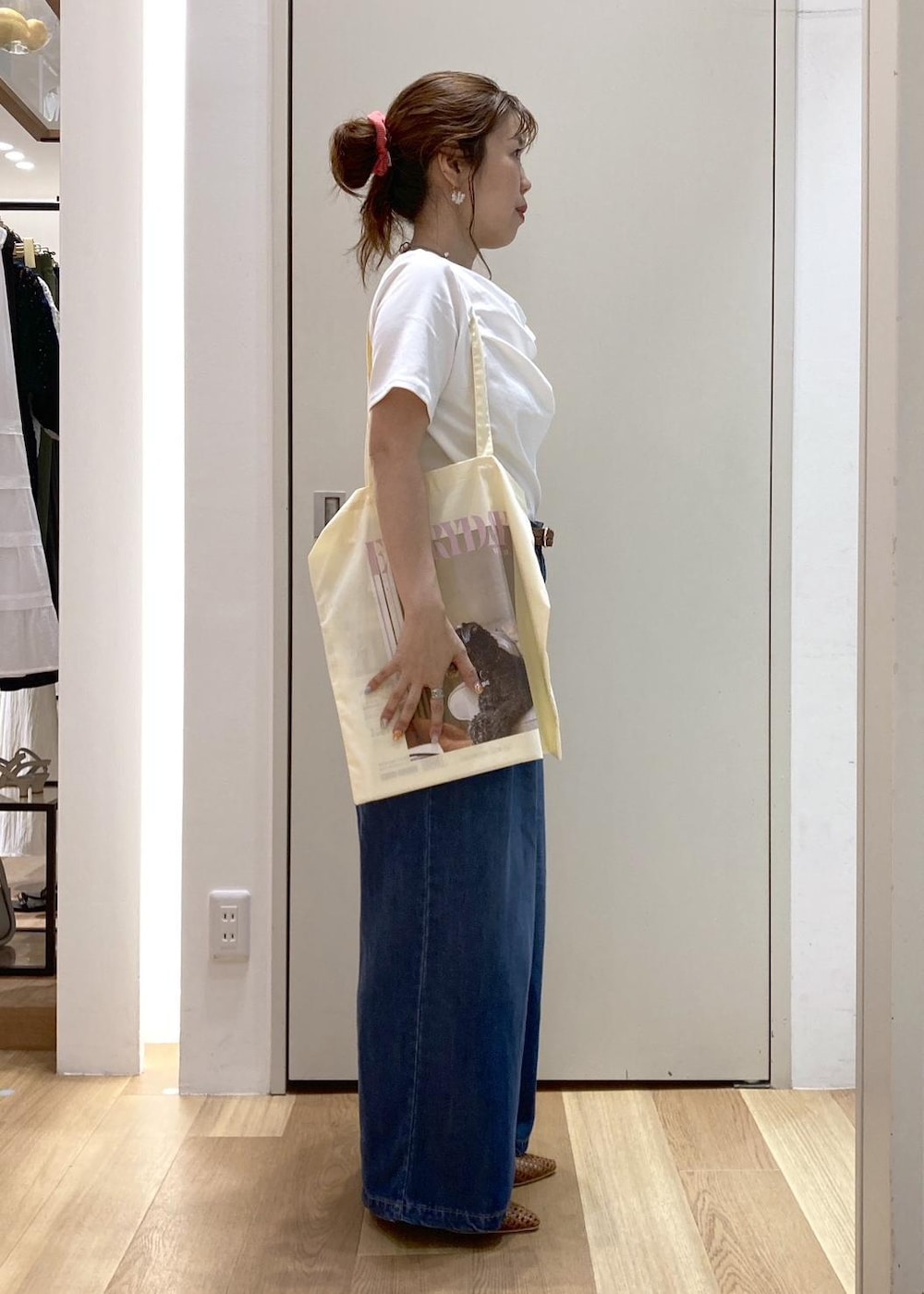 ブラウン系のパンプス、イエロー系のトートバッグ、ブルー系のデニムパンツを着用したレディースの夏コーディネートの2枚目の写真
