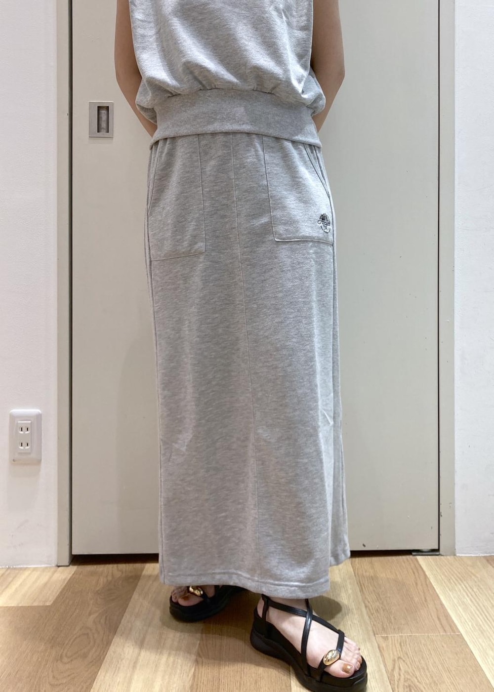 ブラック系のサンダル、グレー系のスカート、グレー系のTシャツ/カットソーを着用したレディースの夏コーディネートの6枚目の写真