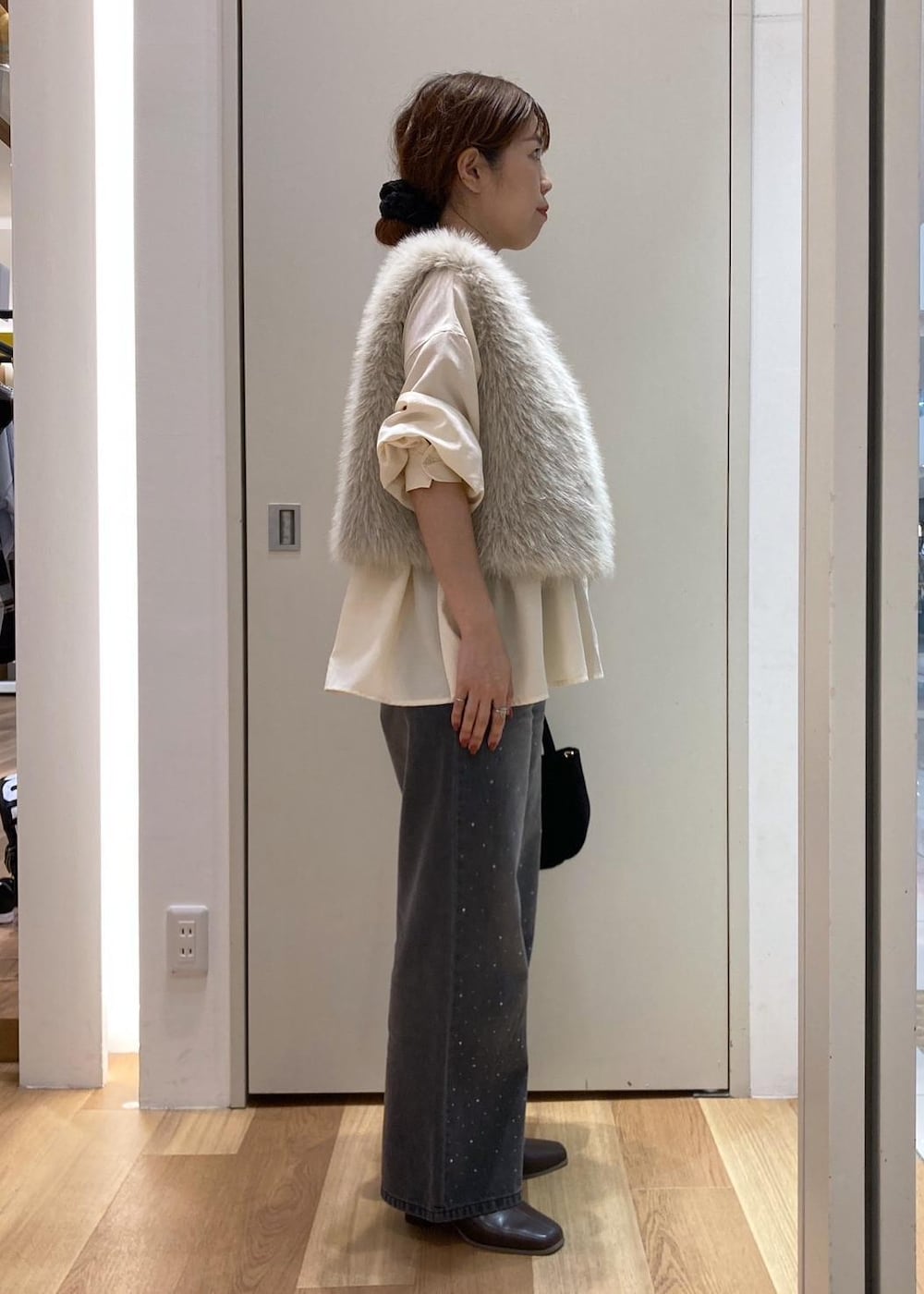 ベージュ系のシャツ/ブラウス、ベージュ系のベスト、ブラック系のデニムパンツを着用したレディースの秋コーディネートの2枚目の写真